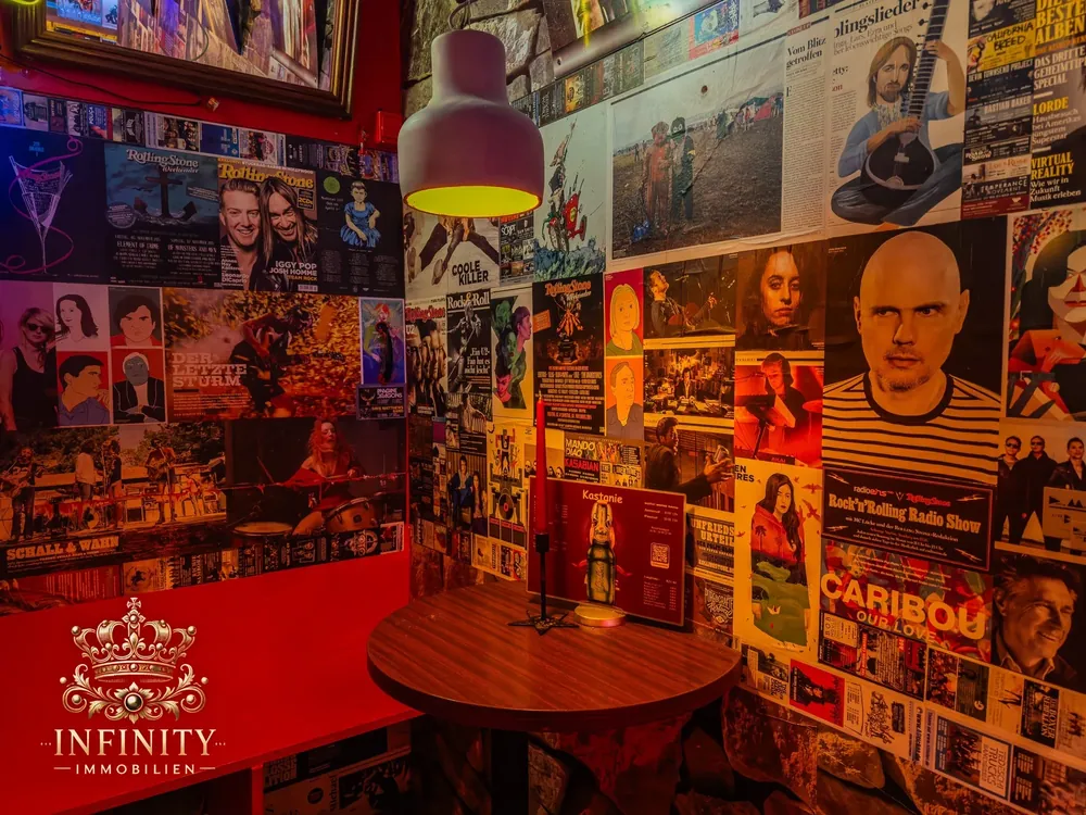 Stehtisch vor Wand mit Musikplakaten